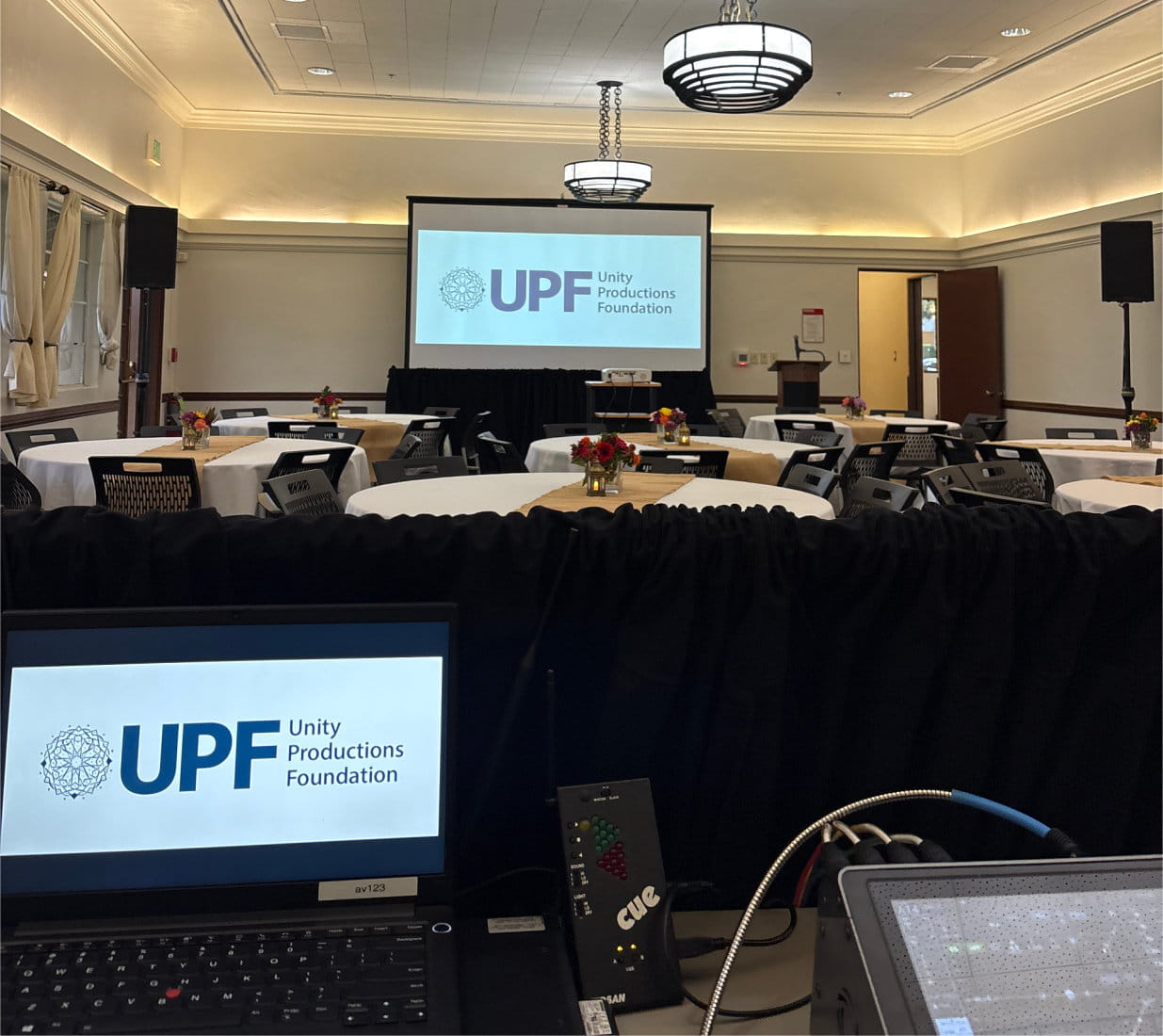 Multi-microphone panel setup and custom architectural uplighting inside a corporate hotel breakout room.