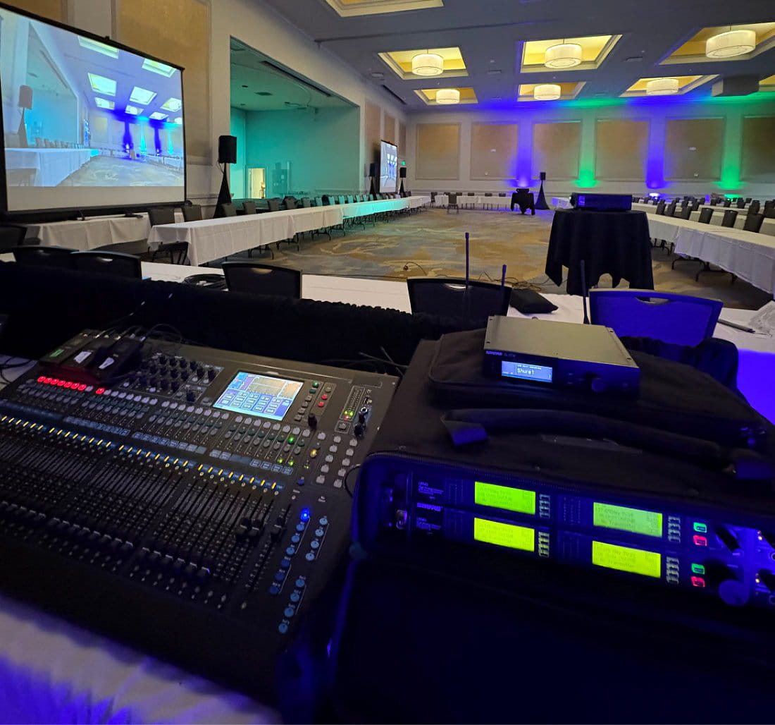 On-site A/V technicians managing multi-camera switching and hardware encoding for a live hotel hybrid event.